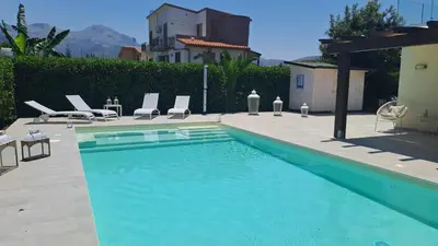 a swimming pool with two lawn chairs at Villa Elios Adriana2 in Lascari