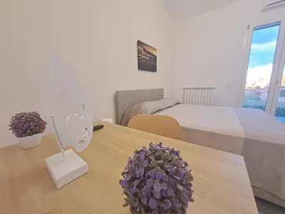 a bedroom with a bed and a table with a potted plant at Villa Elios Adriana2 in Lascari