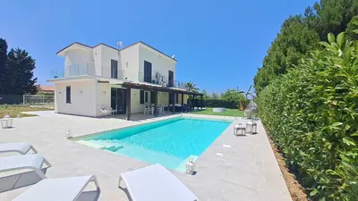 a villa with a swimming pool in front of a house at Villa Elios Adriana2 in Lascari