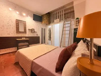 a bedroom with a bed and a table with a lamp at La Casetta del Centro in Palermo