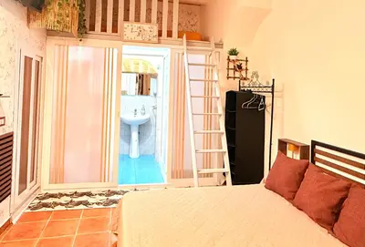a bedroom with a bed and a bathroom with a sink at La Casetta del Centro in Palermo