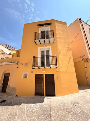 a yellow building with a window and a balcony at Dimora Santa Spina - La Terrazza in Palermo