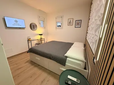 a small bedroom with a bed and a tv at Dimora Santa Spina - La Terrazza in Palermo