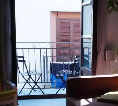 a balcony with chairs and a table on a balcony at Epic terrace in Kalsa in Palermo