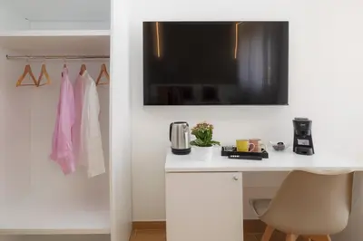 a room with a white desk with a television on a wall at Valenza Exclusive Suites & Rooms in Palermo