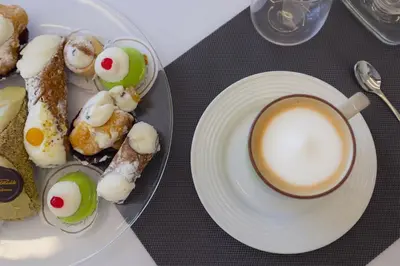 a table with a plate of food and a cup of coffee at Valenza Exclusive Suites & Rooms in Palermo