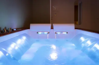 a bath tub with blue water in a bathroom at Valenza Exclusive Suites & Rooms in Palermo