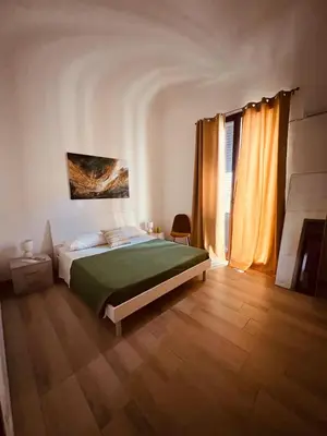 a bedroom with a bed with a green blanket at AL CAPO casa vacanze in Palermo
