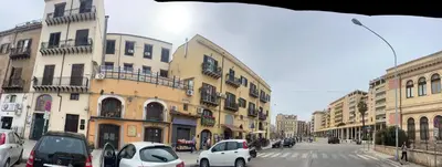 a city street with parked cars and buildings at AL CAPO casa vacanze in Palermo