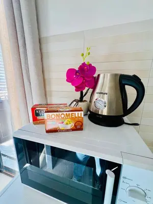 a shelf with a tea pot and flowers on top of a microwave at AL CAPO casa vacanze in Palermo