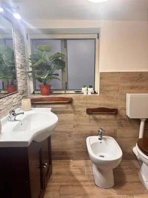 a bathroom with a sink and a toilet and a window at Dimora Albanese in Palermo