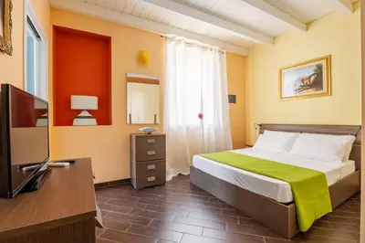 a bedroom with a bed and a television in a room at nonMama - Comfort & charm in Partanna Mondello in Palermo