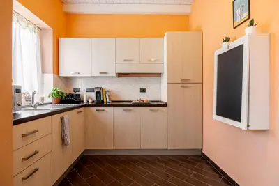 a kitchen with white cabinets and a black refrigerator at nonMama - Comfort & charm in Partanna Mondello in Palermo