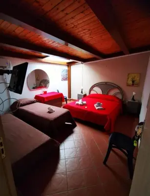 a bedroom with two beds and red sheets at Appartamento politeama Palermo in Palermo