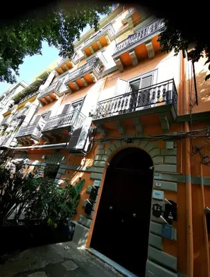 a building with a black door and a balcony at Appartamento politeama Palermo in Palermo