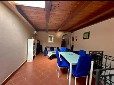 a living room with a table and blue chairs at Appartamento politeama Palermo in Palermo
