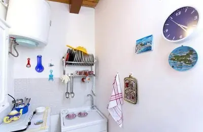a kitchen with clocks on the wall and a sink at Appartamento politeama Palermo in Palermo