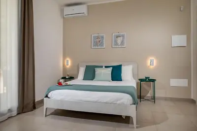 a bedroom with a bed with blue and white pillows at Villa Maria con piscina e vista mare 12 posti letto in Castellammare del Golfo