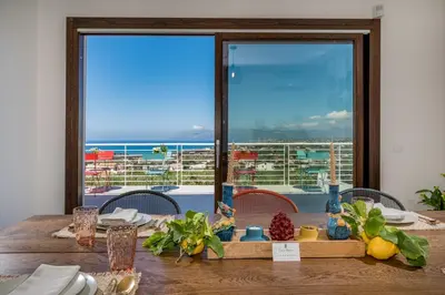 a dining table with a view of the ocean at Villa Maria con piscina e vista mare 12 posti letto in Castellammare del Golfo
