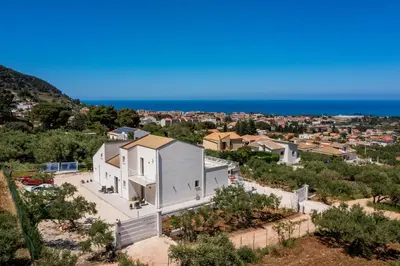 an aerial view of a white house with the ocean in the background at Villa Maria con piscina e vista mare 12 posti letto in Castellammare del Golfo