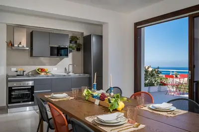 a kitchen and dining room with a table and chairs at Villa Maria con piscina e vista mare 12 posti letto in Castellammare del Golfo