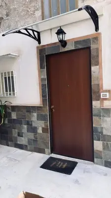 a brown door on a building with a light at Casa AG in Palermo
