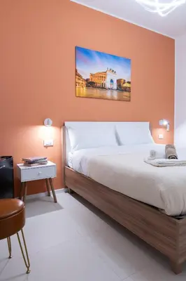a bedroom with a large bed and a table at Duecento Rooms in Palermo