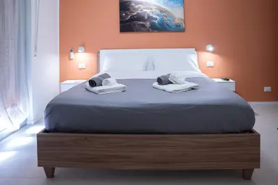a bedroom with a large bed with towels on it at Duecento Rooms in Palermo