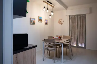 a kitchen and dining room with a table and chairs at Duecento Rooms in Palermo