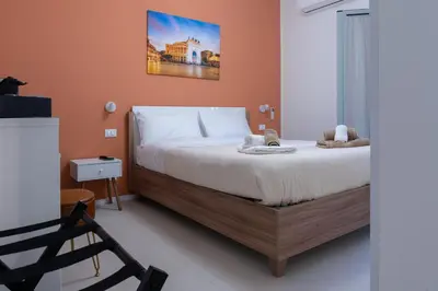 a bedroom with a large bed with white sheets at Duecento Rooms in Palermo