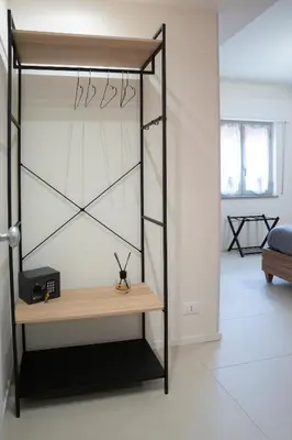 a room with a bed and a shelf with scissors at Duecento Rooms in Palermo