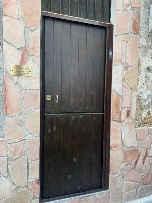 a wooden door in a stone wall at Casa Bastiano in Palermo