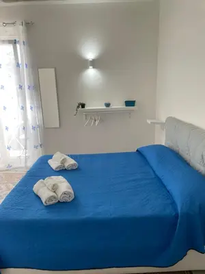 a blue bed with two towels on top of it at Mdue in Palermo