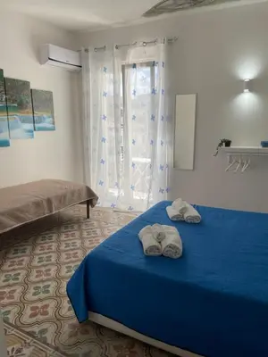 a bedroom with a blue bed with two towels on it at Mdue in Palermo