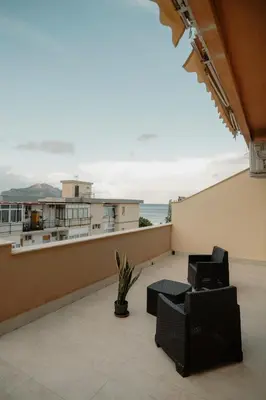 a balcony with chairs and a view of the ocean at Sarina's apartment in Palermo