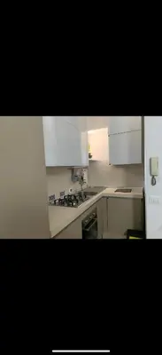 a kitchen with white cabinets and a stove top oven at Al rifugio della stazione in Palermo