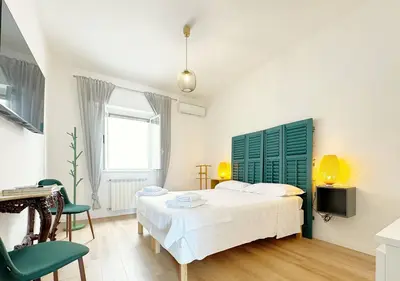 a bedroom with a white bed and a green headboard at Solemar Sicilia - Casa Sabine in Santa Flavia