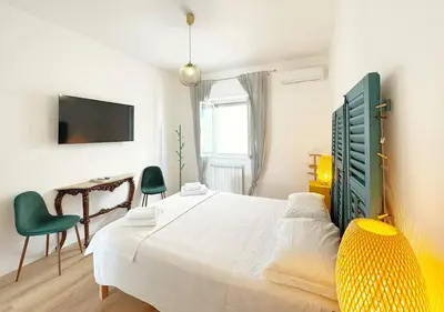 a bedroom with a bed and a table and a television at Solemar Sicilia - Casa Sabine in Santa Flavia