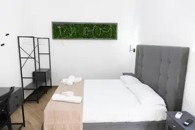 a bedroom with a bed with a green plant on the wall at Adagos in Palermo