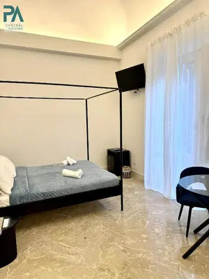 a bedroom with a bed and a tv and a table at Palermo Central Rooms in Palermo