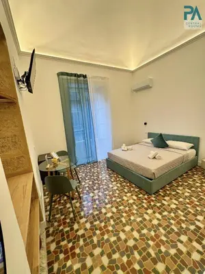 a bedroom with a bed and a table and a desk at Palermo Central Rooms in Palermo