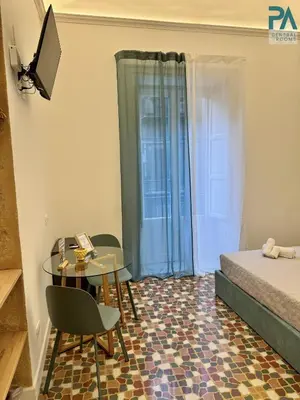 a small room with a table and a bed at Palermo Central Rooms in Palermo