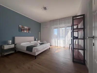 a bedroom with a bed and a wooden floor at Casa Mama in Palermo