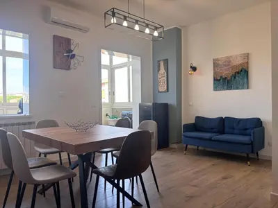 a living room with a table and a blue couch at Casa Mama in Palermo