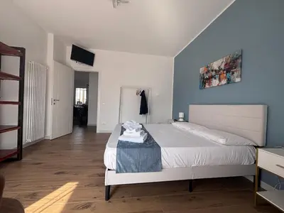 a bedroom with a white bed and a blue wall at Casa Mama in Palermo