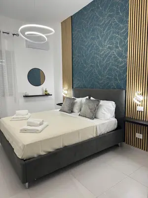 a bedroom with a large bed with a blue wall at Sasi Home in Terrasini