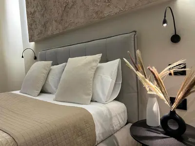 a bedroom with a bed with white pillows and a table at Vulpi 29 Apartment-Deluxe in Palermo
