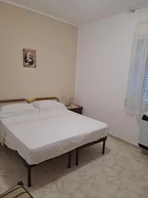 a white bedroom with a bed in a room at ANGELA Rooms in Marineo