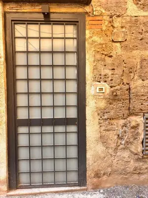 a window with a metal grid on a stone wall at Marie Claire Guest House in Palermo