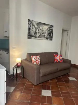 a living room with a brown couch in a kitchen at Tinchitè - A due passi dal Teatro Massimo in Palermo